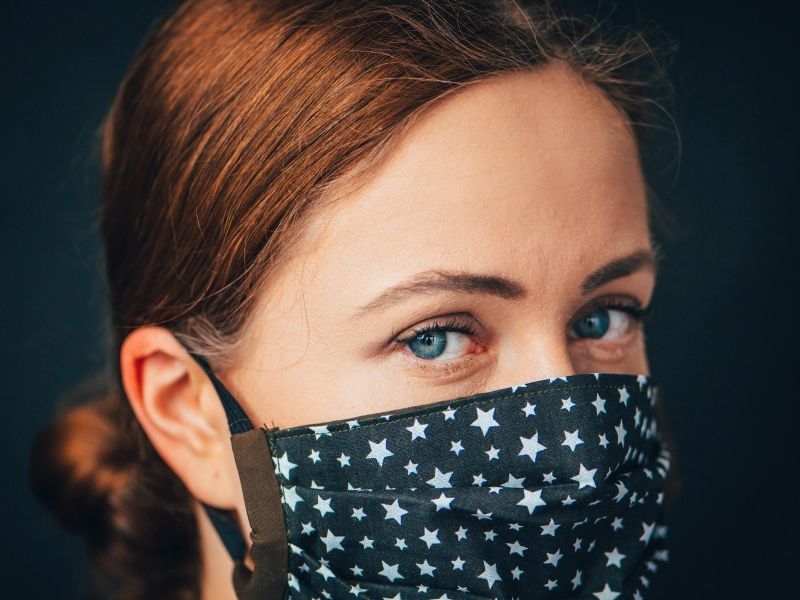 redhead woman wearing blue medical mask with stars