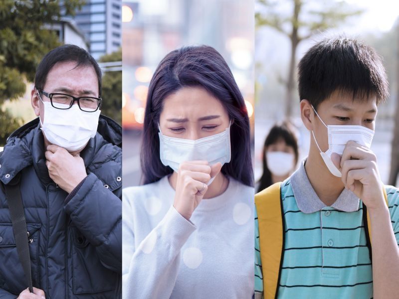 three people wearing face masks coughing into their hands
